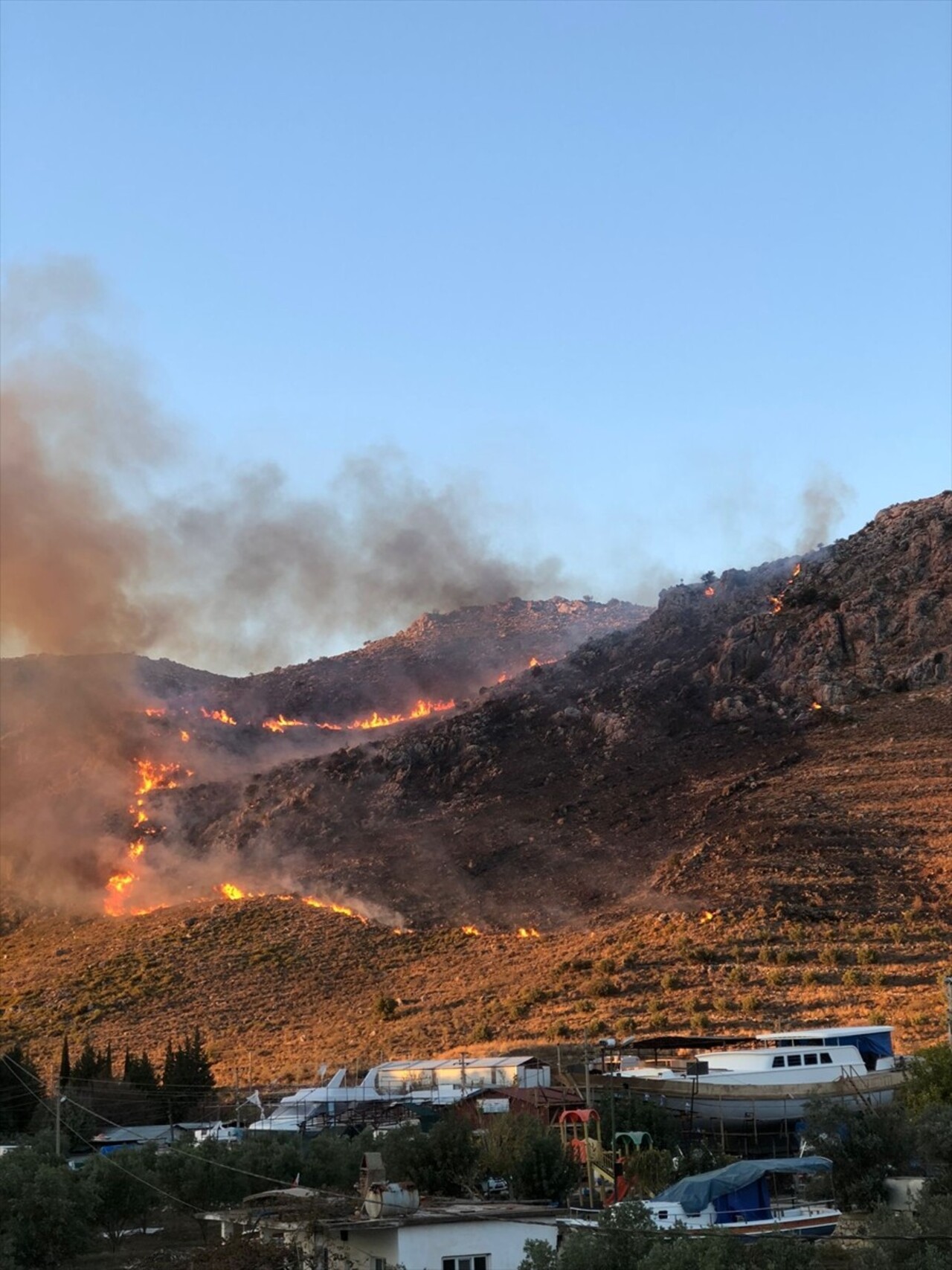 Muğla'nın Marmaris ilçesinde orman dışı makilik alanda çıkan yangın ekiplerin havadan ve karadan...